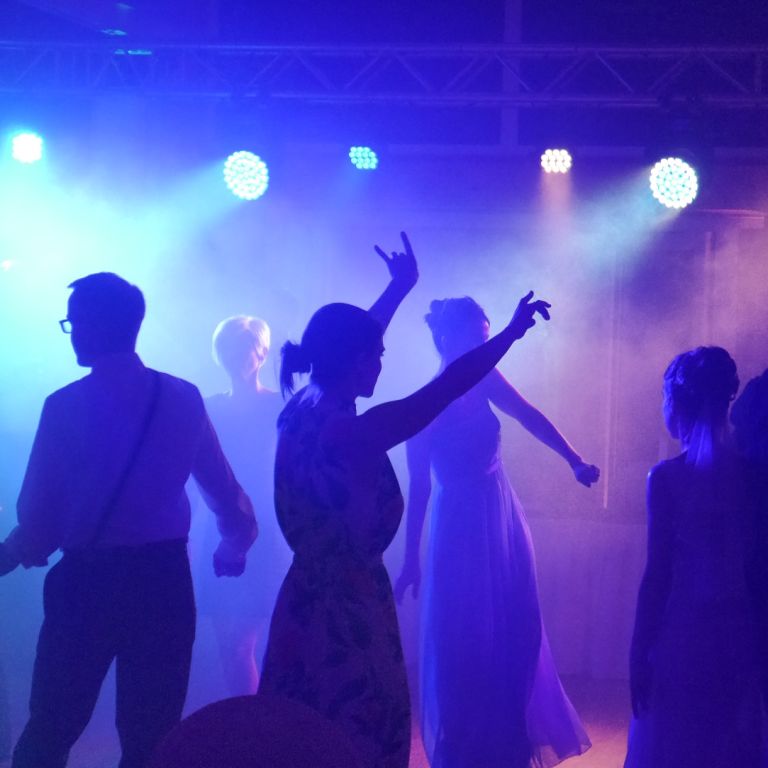 Tanzfläche mit tanzenden Menschen und bunter Beleuchtung