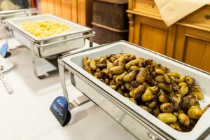 Warmhaltebehälter am Buffet mit gerösteten Kräuterkartoffeln samt Beschriftungsschild.